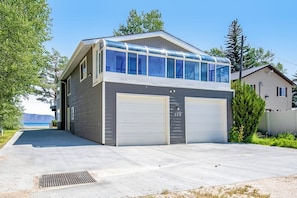 Un edificio a due piani con garage, un livello superiore coperto e vista sull'oceano.