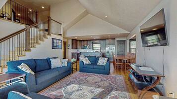A spacious living area with a large sofa, a coffee table, and a patterned rug.