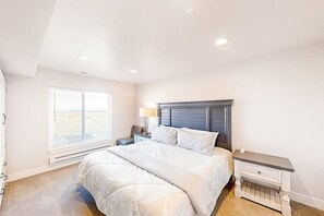 Een slaapkamer met een bed, nachtkastje, lamp en kledingkast.
