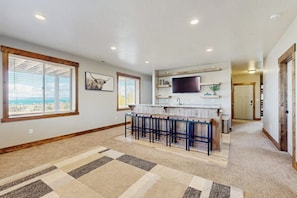 A spacious kitchen with a bar area, large windows, and a view of the outdoors. - The Bear Lake Spot - Lake Views & Wet Bar (Garden City)