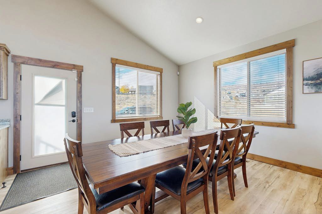 Un comedor con una mesa de madera, seis sillas y una planta en maceta.