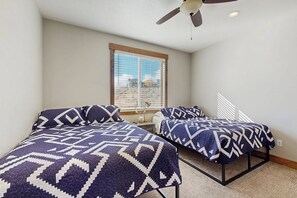 A bedroom with two beds, a ceiling fan, and a window with blinds. - The Bear Lake Spot - Lake Views & Wet Bar (Garden City)