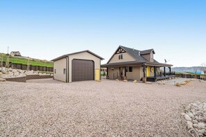 A two-story house with a garage and a covered porch. - Cubbyz Cabin - Lake Views, Hot Tub, Near Marina (Garden City)