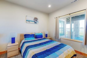 A bedroom with a bed, nightstands, a lamp, a painting, and a window with curtains. - Beachfront Haven - Private Beach, Courts & Views (Laketown)