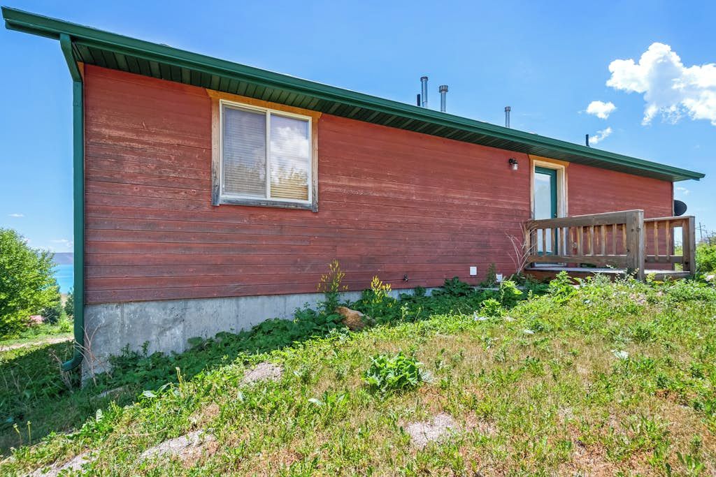 A single-story building with a red exterior, a green roof, and a small porch.