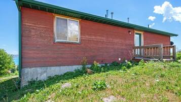 A single-story building with a red exterior, a green roof, and a small porch.