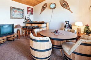 A cozy room with a round wooden table, leather chairs, and a television. - Moose Mountain Retreat (Fish Haven)
