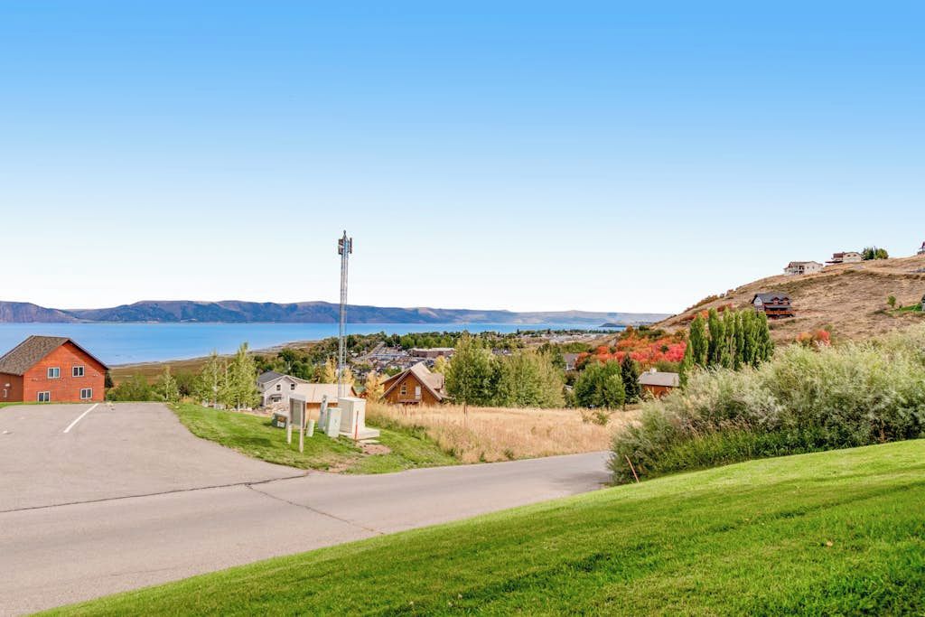 Ett bostadsområde med fri utsikt över en sjö, ett rött hus och ett högt kommunikationstorn.