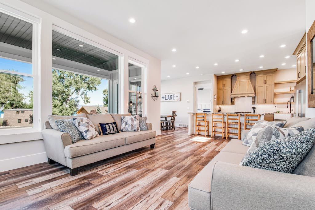 A modern living room with a sofa, a coffee table, and a kitchen area with wooden cabinets and a countertop.