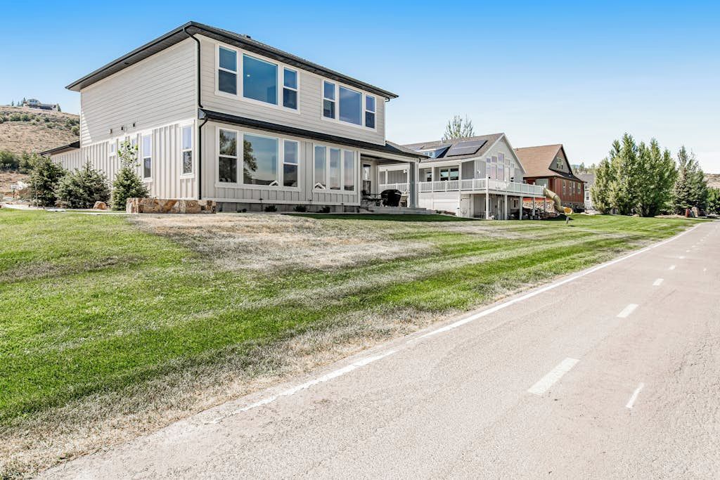 A two-story house with a large front porch, a garage, and a driveway.