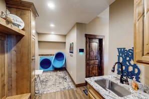 A kitchen with wooden cabinets, a sink, and a rug. - Raspberry Ridge Lodge - Lake Views & Indoor Court (Fish Haven)