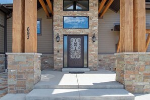 A house with a stone facade, a decorative metal door, and a number '693' on the left pillar. - Raspberry Ridge Lodge - Lake Views & Indoor Court (Fish Haven)