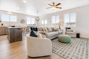 A spacious living area with a sofa, ottoman, and dining table. - Grandma Buddy's House (Garden City)