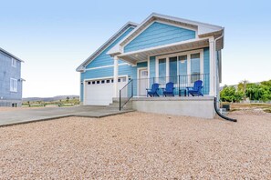 A single-story house with a covered porch, a garage, and a gravel driveway. - Grandma Buddy's House (Garden City)