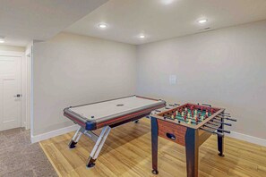 Una stanza con tavolo da calcio e tavolo da biliardo.
