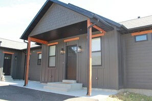 A modern two-story house with a covered porch, a front door, and a garage. - Bear Lake Retreat - Hot Tub & Views, Sleeps 18 (Garden City)