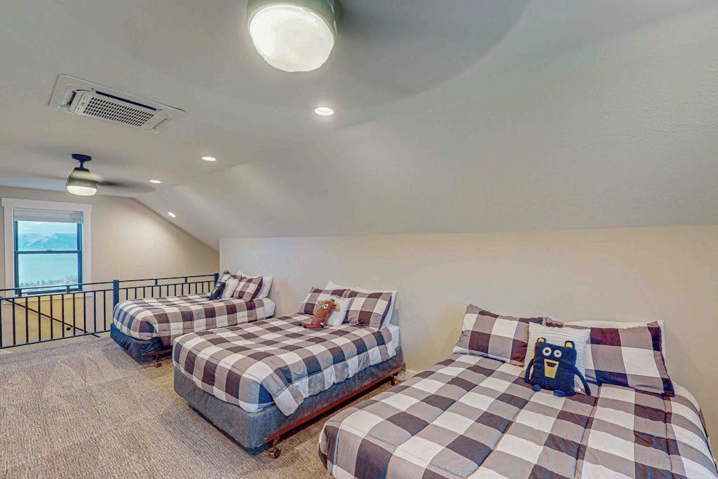 A bedroom with two beds, a window, and a balcony.