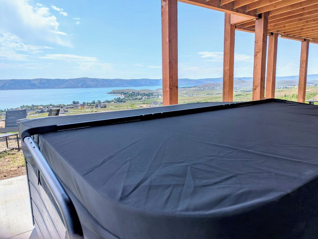 A pool table with a view of a lake and distant mountains.