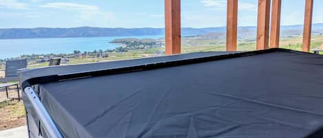 A pool table with a view of a lake and distant mountains.