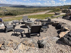 An outdoor seating area with chairs and a table, surrounded by rocks and pebbles. - Bear Lake Retreat - Hot Tub & Views, Sleeps 18 (Garden City)