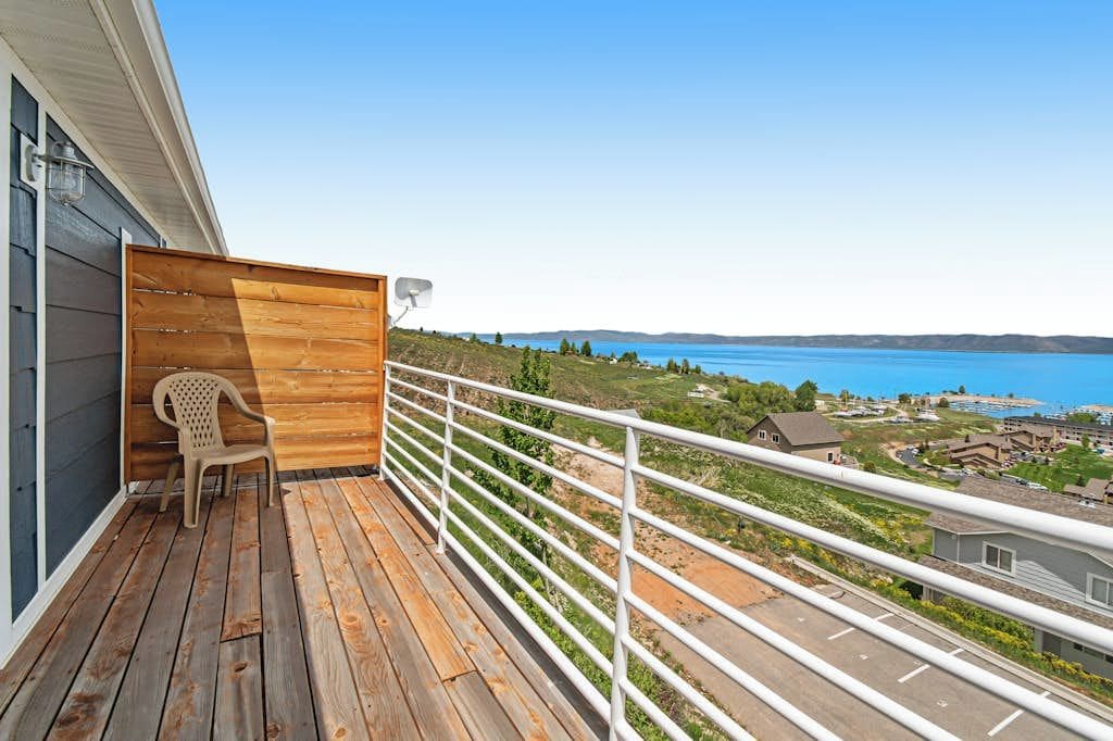 A balcony with a view of a body of water and a resort area.