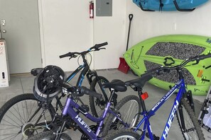 Ein Fahrrad mit violettem und blauem Rahmen, das an einer Wand angelehnt ist.