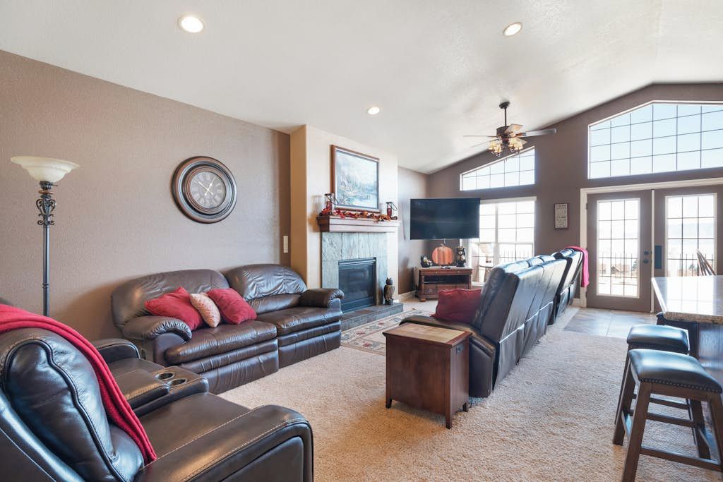 A spacious living room with a fireplace, a television, and a large window.