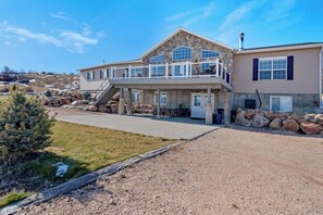A two-story house with a balcony, a stone facade, and a gravel driveway. - The Lakehouse - Lake Views, Sleeps 31, Dogs OK (Garden City)