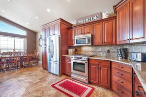 Una cocina con armarios de madera, electrodomésticos de acero inoxidable y un tapete rojo.