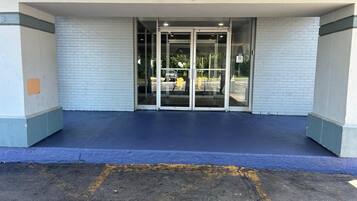 A building entrance with a glass door and a blue-painted ground.