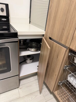 Eine Küche mit Herd, Backofen und Holzschränken.