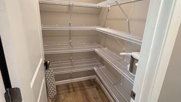 A small, enclosed storage area with metal shelving units and a wooden floor.