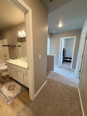 A bathroom with a white sink, mirror, and toilet. - 3-bedroom townhome -8 Miles From Downtown Iowa City (Hills)