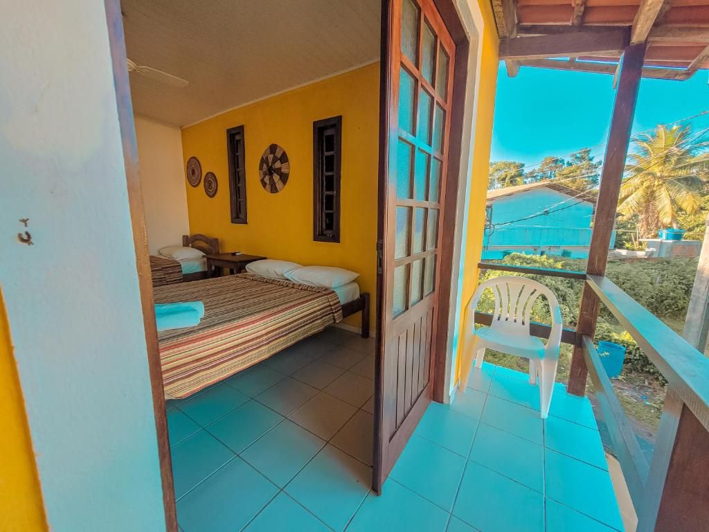 Een kamer met een bed, een raam en uitzicht op een balkon.
