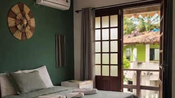Ein Hotelzimmer mit zwei Betten, einem großen Fenster und Blick ins Freie.