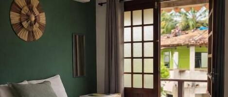 A hotel room with two beds, a large window, and a view of the outside.
