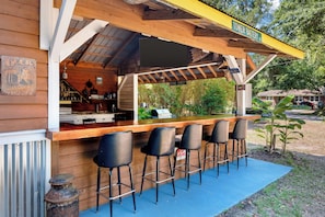A wooden bar with a view of the street, outdoor seating, and a sign indicating 'TOWER BATTERY RD'.