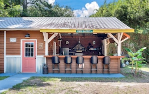 A small building with a yellow awning labeled 'TOWER BATTERY RD' and a bar area with stools. - Quiet and cozy Coastal Cottage (Charleston)