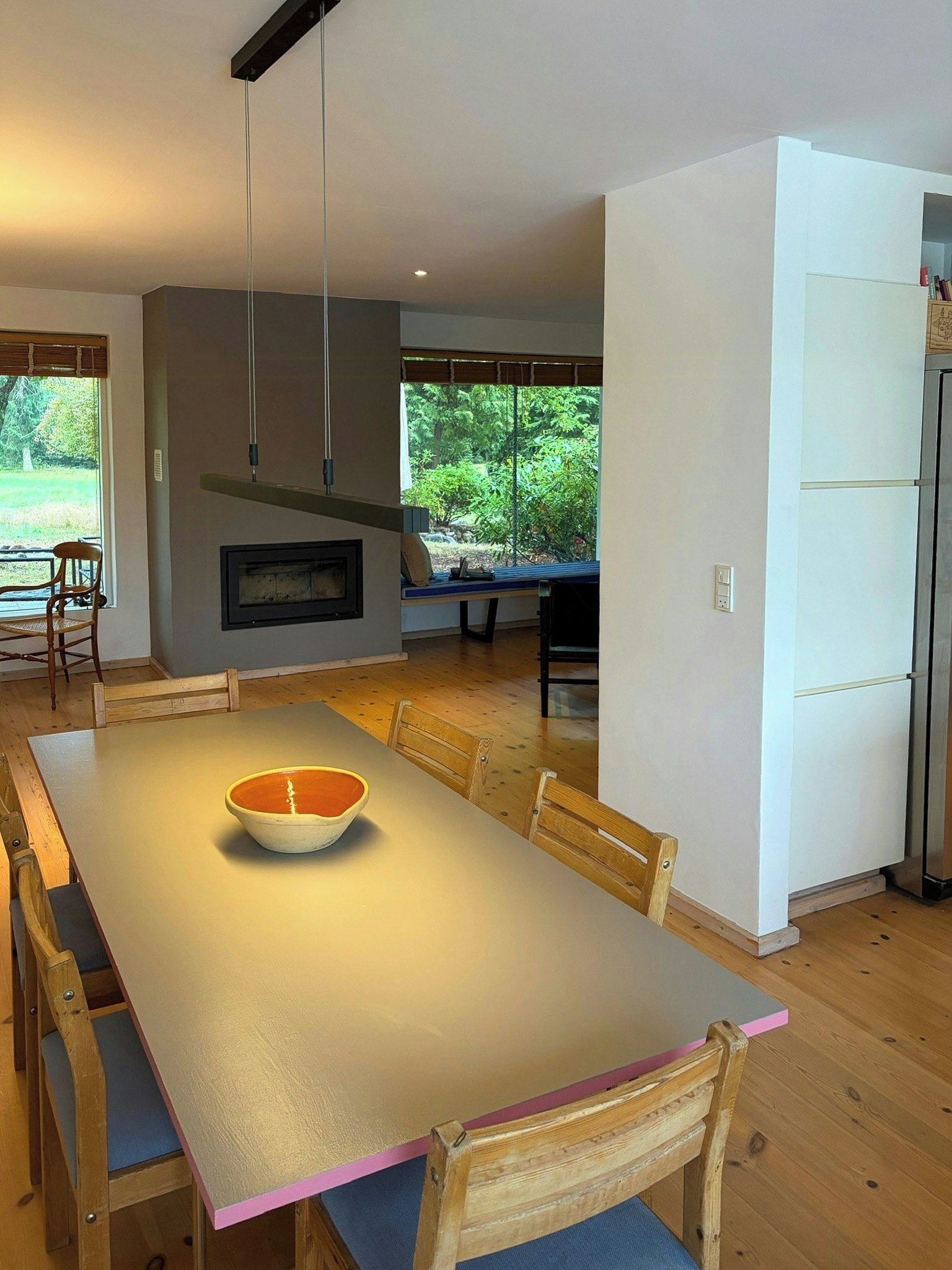 Una cocina moderna con comedor, mobiliario de madera y vistas a zonas verdes.