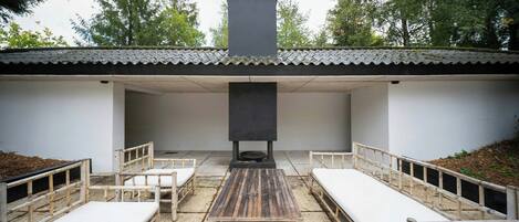 An outdoor seating area with four wooden benches and a central table.