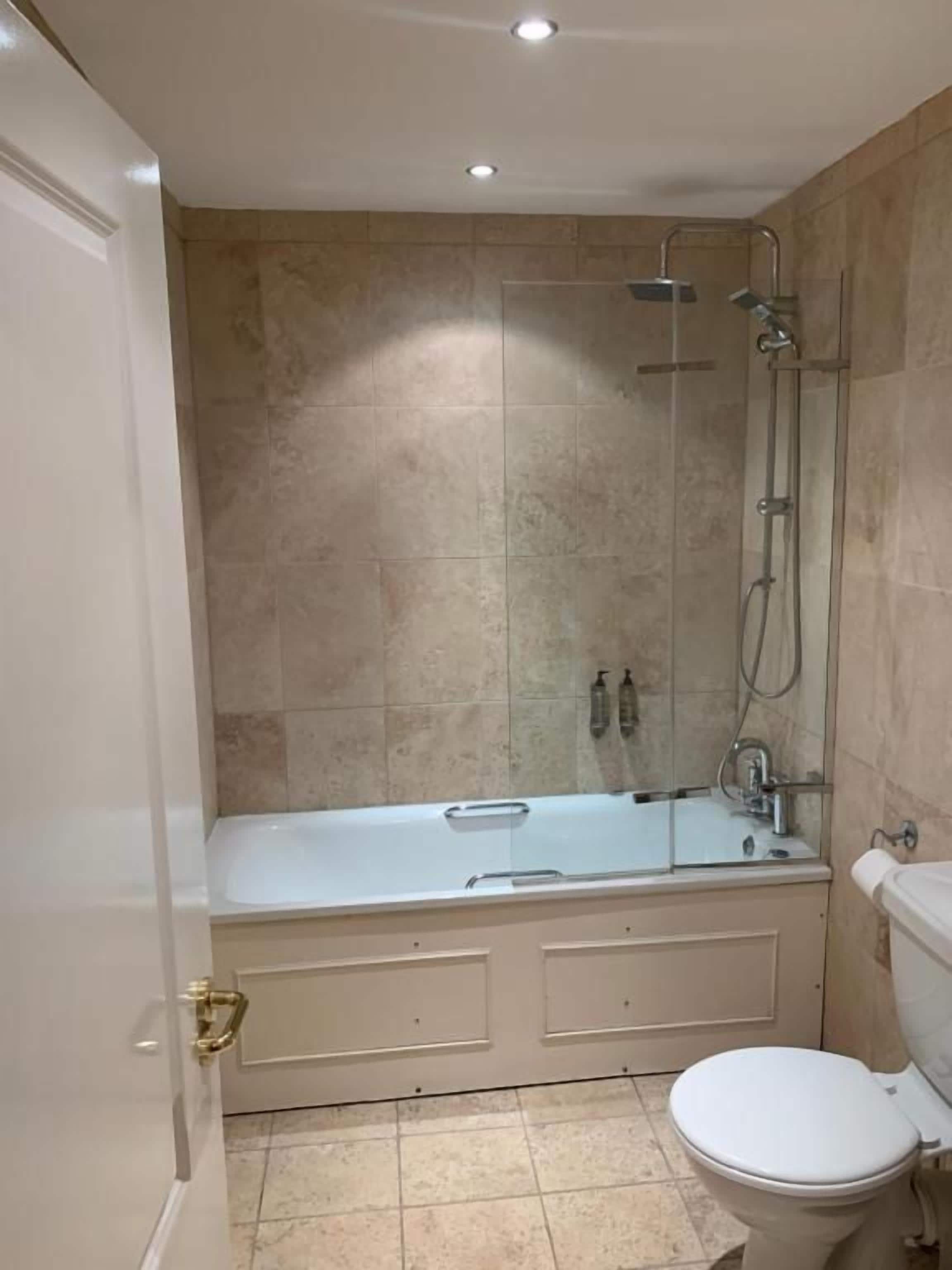 A bathroom with a bathtub, toilet, and shower.