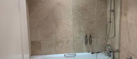 A bathroom with a bathtub, toilet, and shower.
