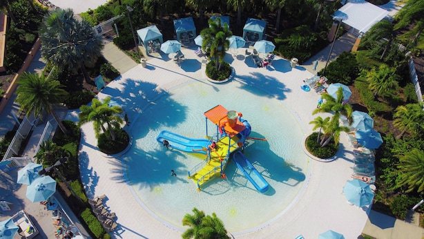 A water park with a central play area, surrounded by lounge chairs and umbrellas. - Family 5BR at Solara with Private Pool (Kissimmee)