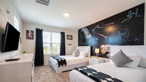 A hotel room with two beds, a TV, a window with curtains, and a Star Wars themed wall mural. - Family 5BR at Solara with Private Pool (Kissimmee)
