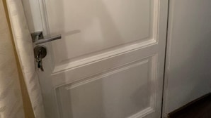 A white door with a number '2' on it, a door handle, and a keychain with keys.