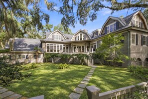 A large, two-story house with a spacious backyard, a covered porch, and a well-maintained lawn. - 61 River Marsh Lane, Kiawah Island (Kiawah Island)
