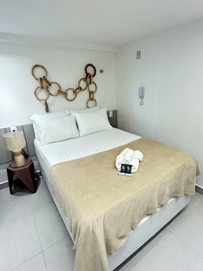 Ein Hotelzimmer mit Bett, Nachttisch mit Lampe und Wanddekoration.