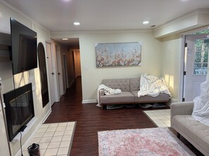 A living room with a fireplace, a sofa, a rug, and a painting on the wall. - Clyde Hill retreat house (Clyde Hill)