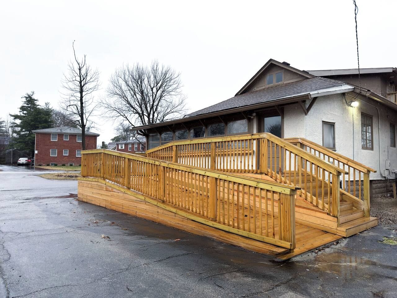 Una terrazza in legno con una scala che conduce a una casa.
