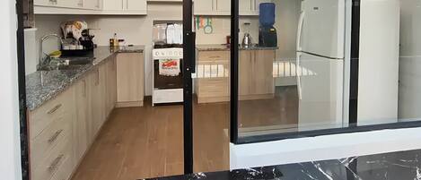 A modern kitchen with white cabinets, a stove, and a refrigerator.